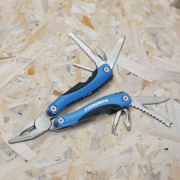 A branded multi-tool laying on a piece of wood.