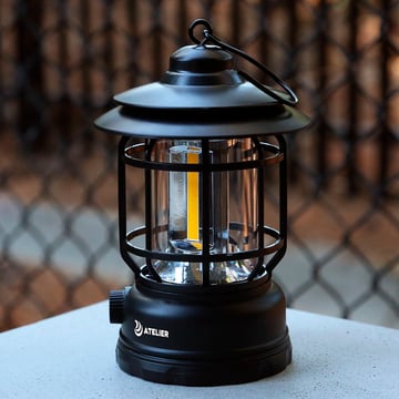 Branded lantern sitting on a table outside.