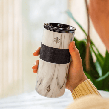 Person holding a marbled tumbler.