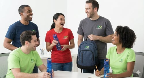 A group of five individuals holding and using promotional products while smiling
